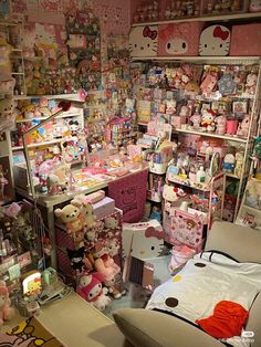 a room filled with lots of stuffed animals and other stuff items in pink boxes on the walls