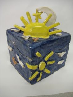 a ceramic box with sun and moon on it