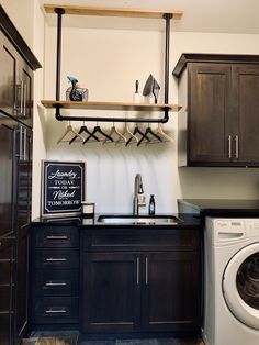 a washer and dryer in a small room with wooden shelves on the wall