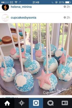 there are many cupcakes with blue and white icing on the cake pops