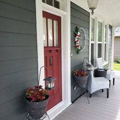 the front porch is decorated for christmas with wreaths and potted plants