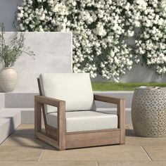 a wooden chair sitting on top of a tile floor next to a white flower pot