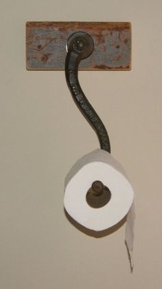 a roll of toilet paper is hanging on the wall with a pipe attached to it