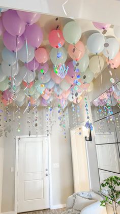 a room filled with lots of balloons and streamers hanging from the ceiling above it