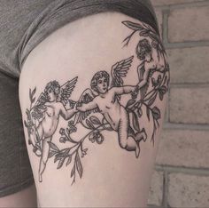 a woman's thigh with an angel and cherub tattoo design on the side