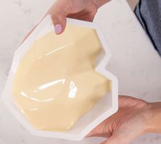 a person holding a container with cream on it