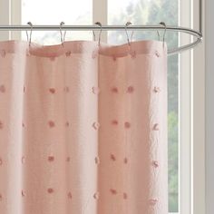 a pink shower curtain hanging in front of a window