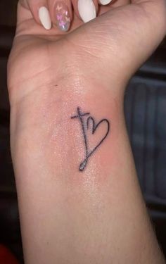 a woman's arm with a small tattoo on the left side of her wrist