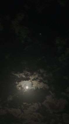 the full moon is shining brightly in the night sky with clouds and dark skies behind it