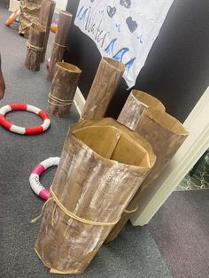 several wooden poles are stacked on top of each other in the middle of a room