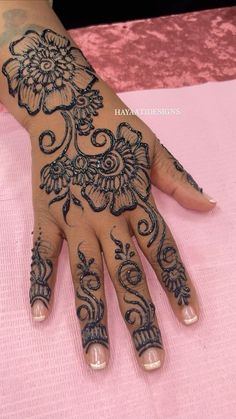 a woman's hand with henna tattoos on it