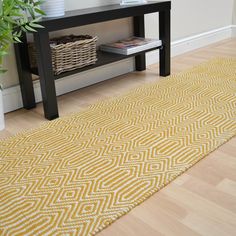 a yellow rug on the floor in front of a black table