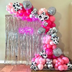 the balloon arch is decorated with pink, silver and black balloons