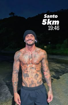 a man with tattoos on his chest standing in front of a dark background and the caption says santo 5 km