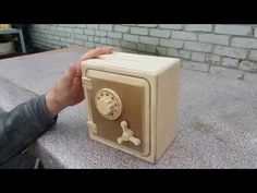 a hand is holding an old fashioned radio on a table outside in front of a brick wall