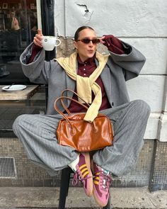 a person sitting on a chair with a purse and coffee cup in front of them