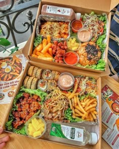 two boxes filled with different types of food on top of a wooden table next to each other