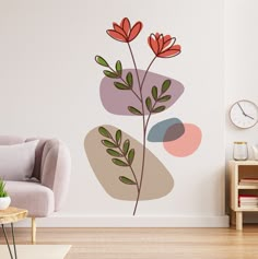 a living room with a couch, chair and wall decal that has flowers on it