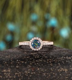 a blue diamond ring sitting on top of a rock