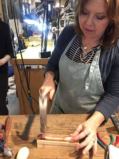 a woman in an apron chopping food on a cutting board