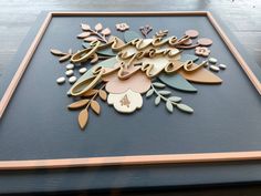 there is a wooden sign with flowers on it that says save the date in gold lettering