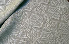 a close up view of a white fabric with an intricate design on it's surface