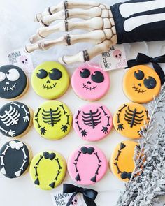 halloween decorated cookies are arranged on a table with skeleton bones and candy wrappers in the background