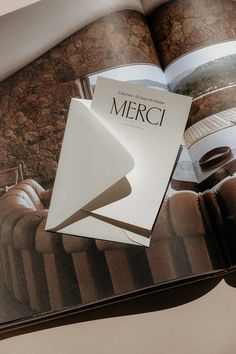 an open book with the title merci written on it's cover and some coffee beans