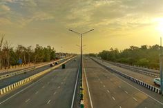 the sun is setting over an empty highway