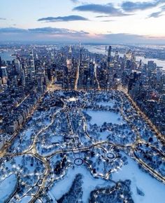 an aerial view of a large city with lots of trees and snow on the ground