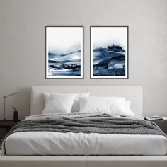 three paintings on the wall above a bed in a room with white sheets and pillows