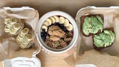 there are many different foods in the containers on this table, including bread and avocado