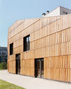 the building is made out of wood and has many windows on each side, along with doors