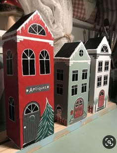 three little houses sitting on top of a wooden shelf