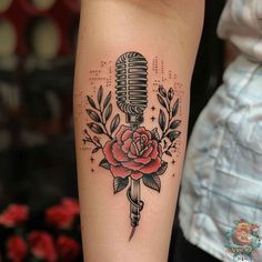 a microphone and rose tattoo on the arm