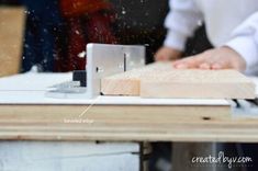 a person working on a piece of wood with a planer in front of them