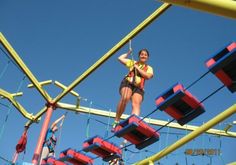 a woman on a rope course in the middle of an obstacle course with ropes and ladders