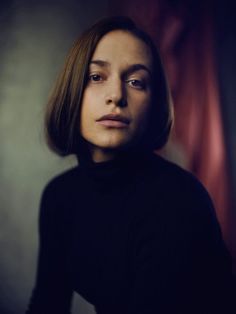 a woman is posing for a photo in the dark, with her eyes half closed