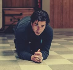 a man is kneeling on the floor pointing at something