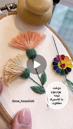 someone is stitching flowers on an embroidery hoop with needle and thread in arabic writing