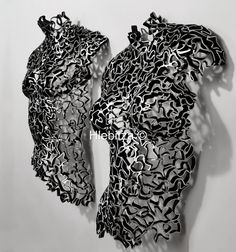 two pieces of black and white art hanging on a wall