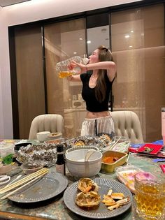 a woman standing in front of a table filled with food