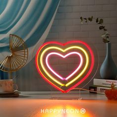 a heart shaped neon sign sitting on top of a table