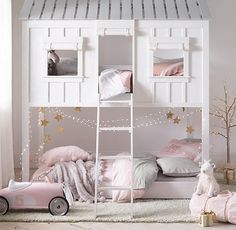 a child's bedroom with a white bunk bed and pink toys on the floor