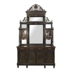 an ornate wooden cabinet with mirror on it's top and two doors open to the side