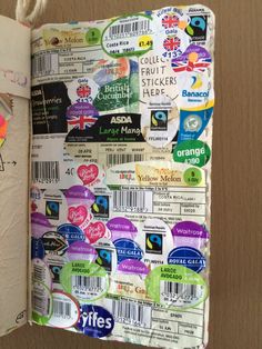 an open notebook with stickers on it and a paper clipping attached to the cover