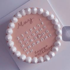 a pink cake with white frosting and numbers on it