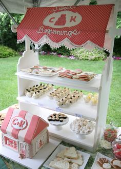 an outdoor dessert table is set up with cookies and other treats on it, including marshmallows