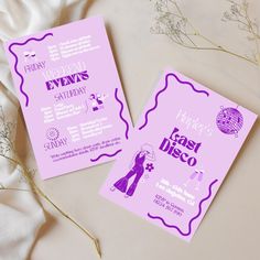 two purple wedding cards on top of a white sheet