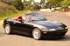 a black sports car is parked on the side of the road